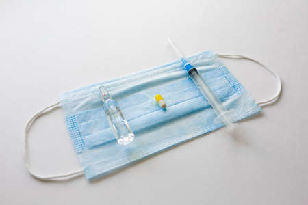 Coronavirus prevention medicall blue mask, syringe and pills on white backgroundの写真素材