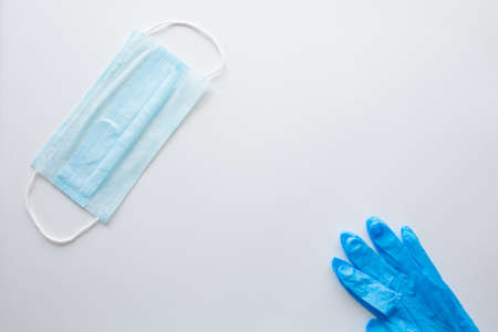 Medical gloves and a surgical face mask on a white background.Concept pandemic Covid-19, coronavirus...