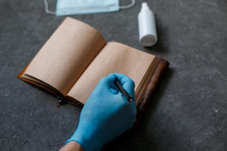 The concept of working from home in the coronavirus pandemic. Protection from covid-19 face mask antiseptic and tablet notepad on a gray background.の写真素材