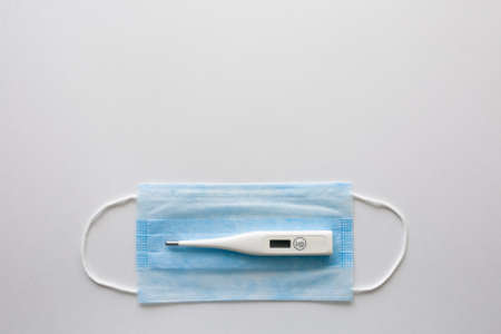 coronavirus background. White medical mask and thermometer on white Face mask protection against pollution, virus, flu and coronavirus. Health care and surgical concept.の写真素材