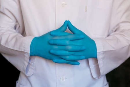 doctor close-up. Surgeon's medical gloves on black background.の写真素材
