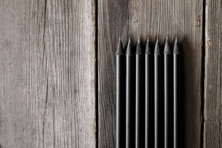 Sharp graphite pencils on wooden background, closeup