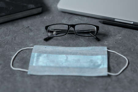 Work from home. Keyboard, phone, protective medical mask, antiseptic on the table. The concept of remote work during the quarantine coronavirus, copy space.の写真素材