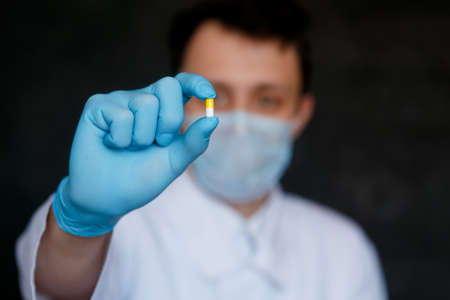the pill in the hands of the doctor close-up. gesture ok. Medic gives the pill to the patient.の写真素材