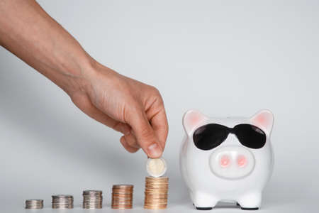 investing in a financial airbag for a future good life. hand holding a piggy bank white background coinsの写真素材