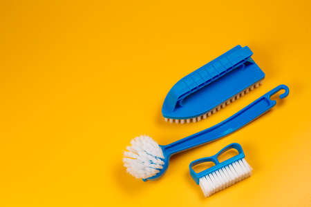 blue brushes for washing clothes and toilet bowl on a yellow background.の写真素材