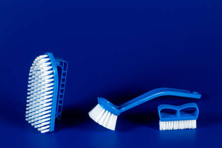 blue brushes for washing clothes and toilet bowl on a blue background.