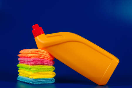 yellow cleaner and rags on a blue background.の写真素材