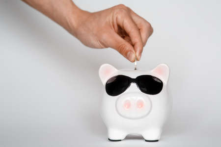 investing in a financial airbag for a future good life. hand holding a piggy bank white background coinsの写真素材