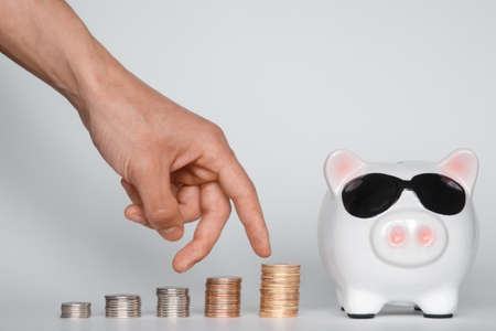 investing in a financial airbag for a future good life. hand holding a piggy bank white background coinsの写真素材