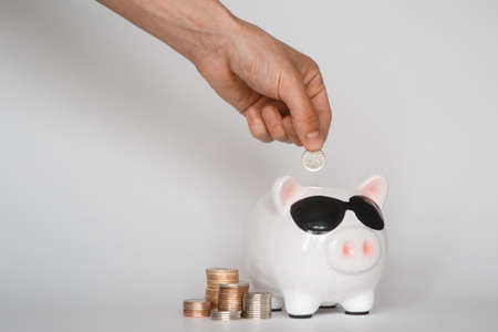 investing in a financial airbag for a future good life. hand holding a piggy bank white background coinsの写真素材