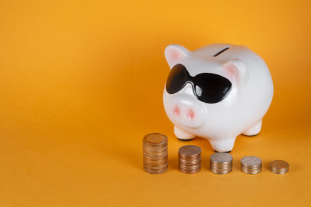financial savings for a good life. piggy bank and coins yellow backgroundの写真素材