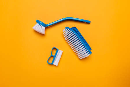 blue brushes for washing clothes and toilet bowl on a yellow background.の写真素材