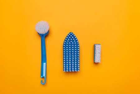 blue brushes for washing clothes and toilet bowl on a yellow background.の写真素材