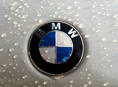 Editorial image. BMW sign with raindrops under the slanting rays of the sunのeditorial素材