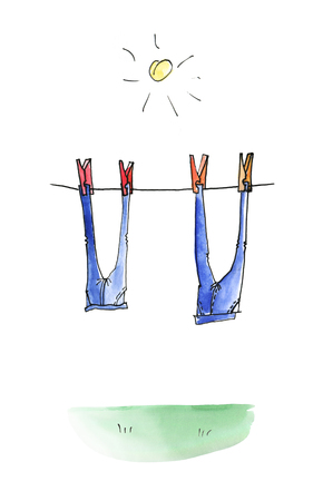 Two pairs of jeans are dried on a rope in the sunの写真素材