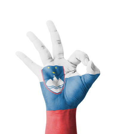 Hand making Ok sign, Slovenia flag painted as symbol of best quality, positivity and success - isolated on white backgroundの写真素材