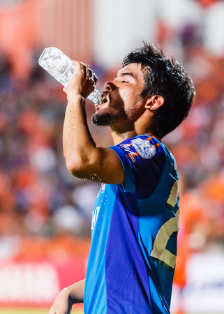 SISAKET THAILAND-JUNE 21: Kroekrit Thaweekarn of Singhtarua FC. drinking water during Thai Premier League between Sisaket FC and Singhtarua FC at Sri Nakhon Lamduan Stadium on June 21,2014,Thailandのeditorial素材