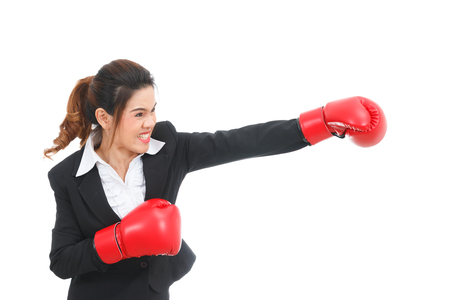 Asian business woman with boxing gloves punching isolated on white backgroundの写真素材