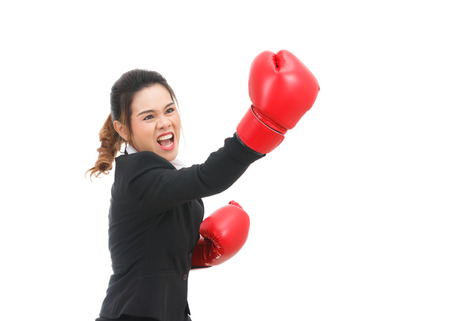 Asian business woman with boxing gloves punching isolated on white backgroundの写真素材