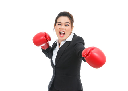 Asian business woman with boxing gloves punching isolated on white backgroundの写真素材