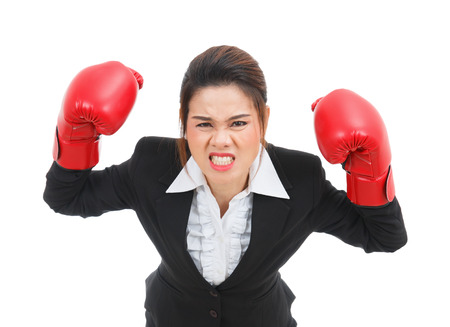 Asian business woman with boxing gloves angry isolated on white backgroundの写真素材
