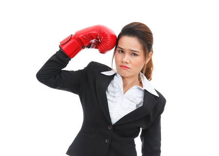 Asian business woman hitting herself with boxing gloves isolated on white backgroundの写真素材