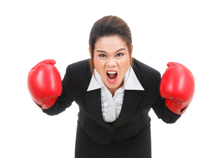 Asian business woman with boxing gloves angry isolated on white backgroundの写真素材