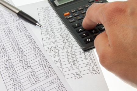 Hand working on a calculator for accounting purposesの写真素材