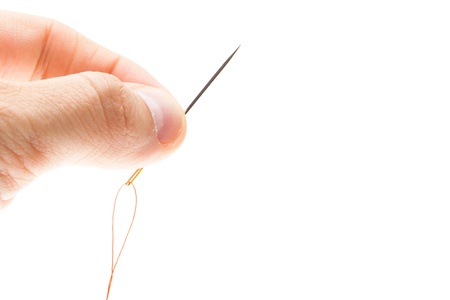 Needle and thread in hand closeup  Isolated on white backgroundの写真素材