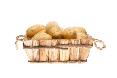bunch of freshly harvested potatoes in a wooden basket on a white backgroundの写真素材