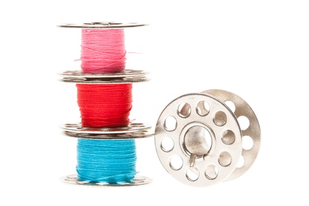 Metal spools of thread isolated on white