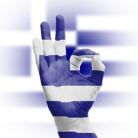 hand OK sign, wrapped in the flag of Greeceの写真素材