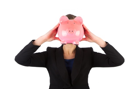 Business woman holding a piggy bank in front of her face against a white backgroundの写真素材