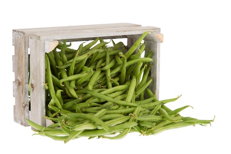 Wooden crate lying on its side with fresh green beans coming outの写真素材