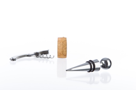 Wine stopper with a cork and metal corkscrew in the background. On a reflective surface and white backgroundの写真素材
