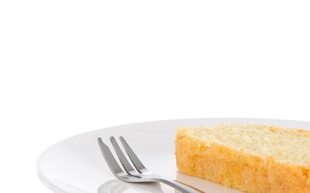 One slice of fresh homemade butter cake and a fork on a white plate with room for copy spaceの写真素材
