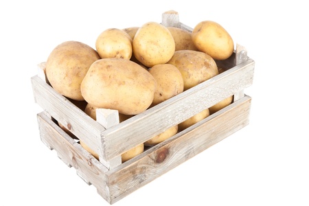 bunch of freshly harvested potatoes in a wooden crate viewed from aboveの写真素材