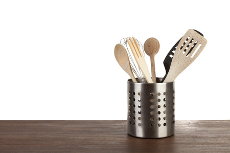 Stainless steel container with kitchen utensils on a wooden surfaceの写真素材