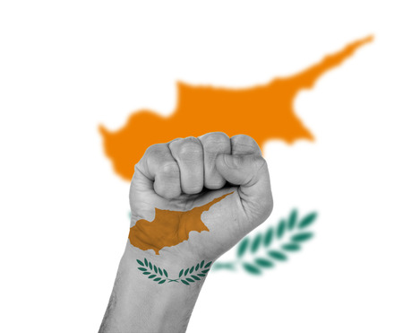Fist wrapped in the flag of Cyprus and flag in the backgroundの写真素材