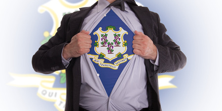 Businessman rips open his shirt to show his Connecticut flag t-shirtの写真素材