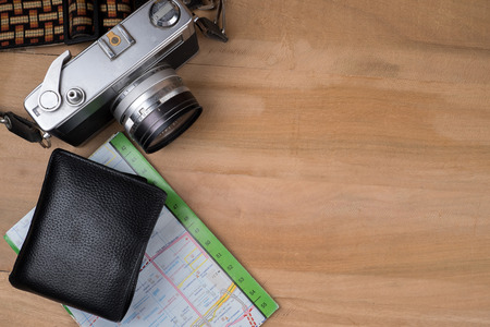 Prepare for travel concept. Top view of vintage camera map wallet  on wooden table background