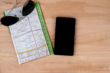 Prepare for travel concept, sun glasses map and mobile on wooden table backgroundの写真素材