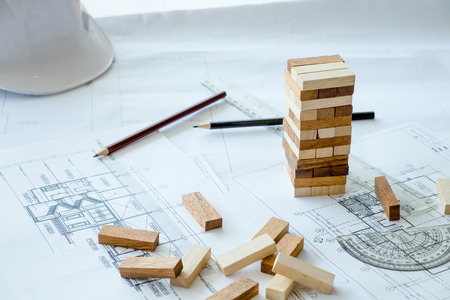 Planning, risk and strategy of project management in business, businessman and engineer gambling placing wooden block on a tower.Business and construction concept.の写真素材