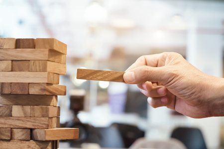 Planning, risk and strategy in business, businessman and engineer gambling placing wooden block on a towerの写真素材