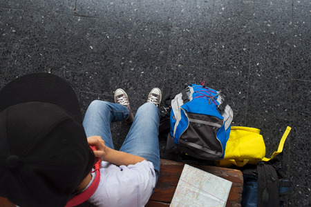 Young hipster girl traveller waiting for next journey trip. Traveler journey trip concept.の写真素材