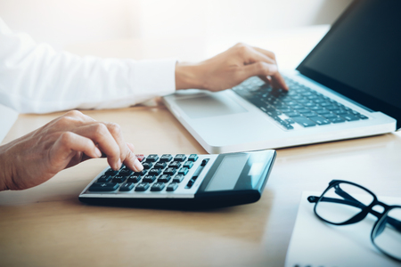 Finances Saving Economy concept. Female accountant or banker use calculator.の写真素材