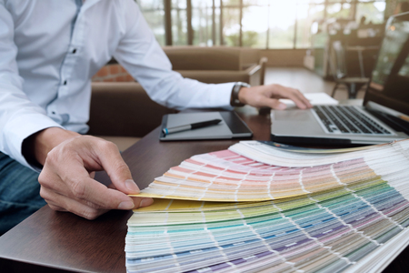 Graphic design and color swatches and pens on a desk. Architectural drawing with work tools and...