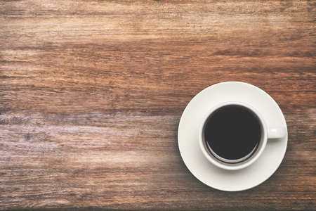 Coffee cup top view on wooden table background. Copyspace and background vintage tone.の写真素材