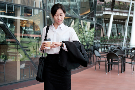 Business woman walking drinking coffee. Lawyer professional or similar walking outdoors happy holding disposable paper cup. Businesswoman smiling happy outside.の写真素材